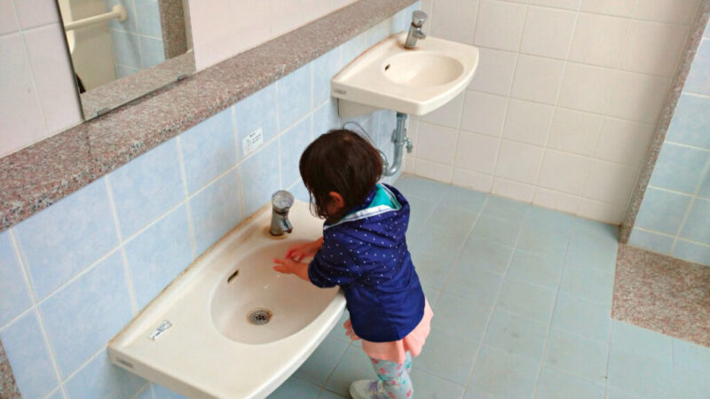 バンナ公園トイレの子ども用手洗い台で手を洗う娘
